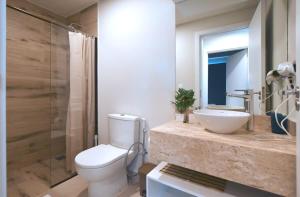 a bathroom with a white toilet and a sink at Cozy 1BR Desk Pool & Terrace in Fernando de la Mora