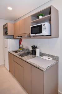 a kitchen with a sink and a microwave at Cozy 1BR Desk Pool & Terrace in Fernando de la Mora +12 photos