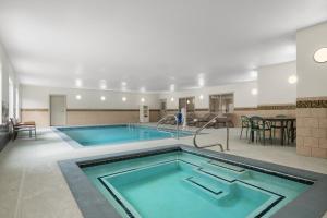 a large pool with two swimming pools in a building at Garner Hotel Madison - Huntsville Airport by IHG in Madison