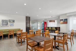 a dining room with tables and chairs in a restaurant at Garner Hotel Madison - Huntsville Airport by IHG in Madison