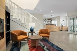 a lobby with two chairs and a table and stairs at Garner Hotel Madison - Huntsville Airport by IHG in Madison