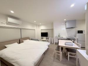 a bedroom with a bed and a desk and a kitchen at Tiz wan hotel in Sumoto