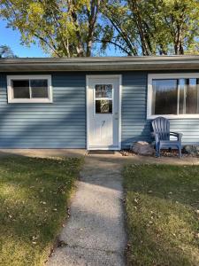 a blue house with a chair in front of it at Lake Wisconsin Resort in Harmony Grove