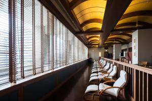 a row of chairs in a waiting room with windows at Hotel Monterey La Soeur Osaka in Osaka