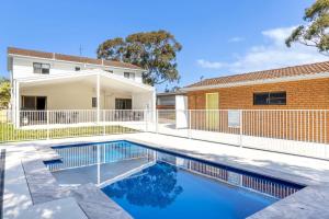 a swimming pool in front of a house at Callala On King - Pet Friendly - Swimming Pool in Callala Beach