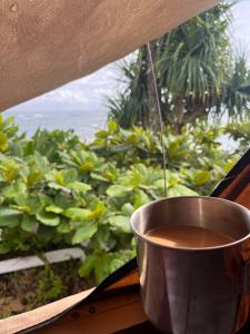 a cup of coffee sitting on a window sill at Island Breeze Rooftop Camper fully equipped rubicon in Anahola +2 photos