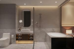 a bathroom with a sink and a tub and a toilet at D'Celes Hotel in Làng Tiên Cát +25 photos