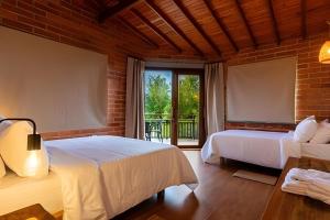 a bedroom with two beds and a large window at Unique Guatapé in Guatapé +151 photos