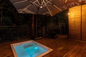 a hot tub on a deck with an umbrella at Unique Guatapé in Guatapé