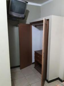 Habitación con TV y armario con tocador. en Hotel Ecologico Riverside, en Quevedo