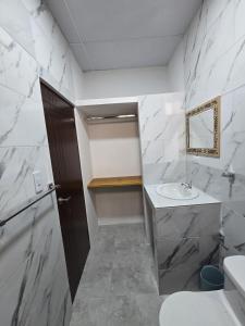 a white bathroom with a sink and a mirror at Hammerhead Shark Apartment in Puerto Baquerizo Moreno +19 photos