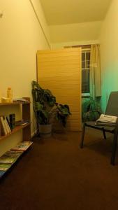 a living room with a wooden door and a plant at Ranfurly Hostel with Sauna in Ranfurly