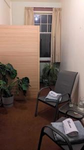 a room with two chairs and a table and a window at Ranfurly Hostel with Sauna in Ranfurly