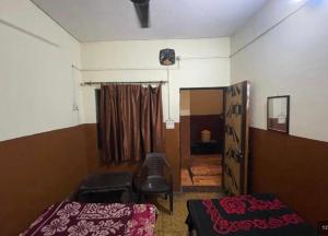 a room with two beds and a chair in it at Shivangi hotel in Bareilly