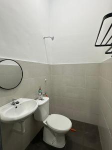 a bathroom with a white toilet and a sink at Khaeel Homestay in Ipoh