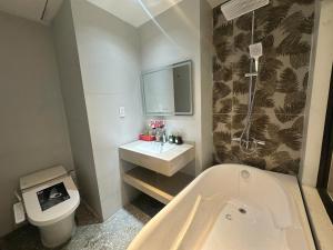 a bathroom with a tub and a toilet and a sink at Hotel 19 in Mỹ Lộc +26 photos
