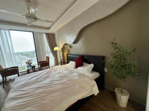 a bedroom with a large bed with a plant in it at Hotel 19 in Mỹ Lộc