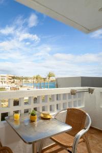 a table and chairs on a balcony with a view of the beach at Aris Studios in Hersonissos