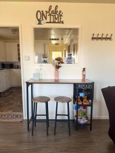 a kitchen with a counter with two stools and a mirror at Lakeside Dune Getaway in Lakeside +22 photos