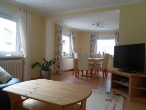 a living room with a table and a television at Burgblick Rech - Ahrtal in Rech