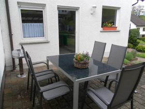 a table with chairs and a basket of flowers on it at Burgblick Rech - Ahrtal in Rech