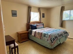 a bedroom with a bed and a table and window at Lakeside Dune Getaway in Lakeside