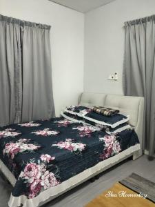 a bedroom with a bed with a floral patterned blanket at SHA HOMESTAY Budget in Tampin