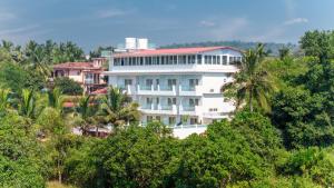 a white building in the middle of trees at Yellowstone Resort Arambol in Arambol