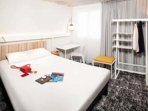 a hotel room with a bed and a desk at Ibis Pontarlier in Pontarlier +37 photos