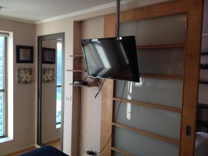 TV de pantalla plana colgada en la pared de una habitación en Departamento Hernan, en Viña del Mar