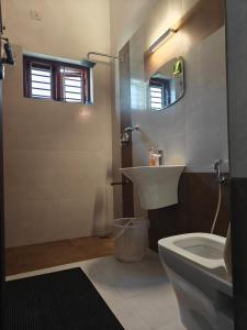 a bathroom with a sink and a toilet at Pratheeksha Homestay in Kannur