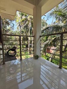 a balcony with a view of a palm tree at Pratheeksha Homestay in Kannur