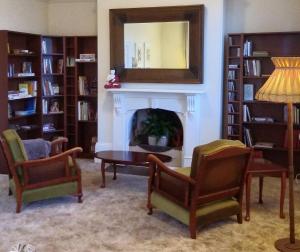 sala de estar con chimenea, mesa y sillas en The Bank Guesthouse Glen Innes, en Glen Innes