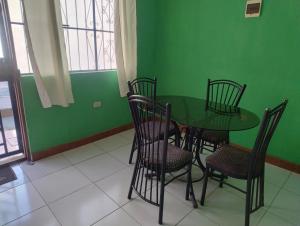 a green dining room with a table and chairs at Curuwasi in Moyobamba