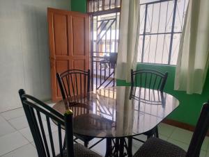 a dining room with a glass table and chairs at Curuwasi in Moyobamba +7 photos