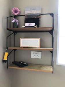 a shelf with a radio and a clock on a wall at Fantail at Bluestone Retreat in Leeston