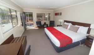 a bedroom with a large bed and a balcony at Amity Motel in Stratford