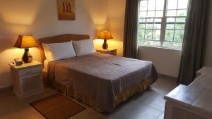 a bedroom with a bed with two lamps and a window at Shades in Saint James +38 photos