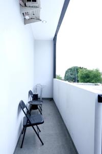 a chair in a room with a white wall at Aurora House Surabaya in Wijung