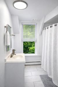 a white bathroom with a sink and a window at Game Room Fun Extended Stay Friendly in Danielson