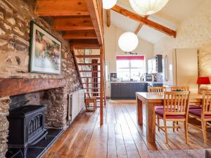 a living room with a fireplace and a table and chairs at Dovetail Cottage in Llangollen