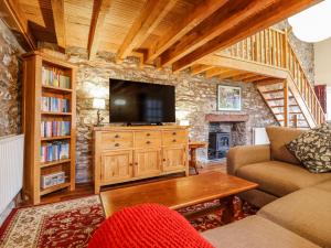 a living room with a couch and a tv at Dovetail Cottage in Llangollen