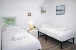 two beds in a room with white walls at Game Room Fun Extended Stay Friendly in Danielson