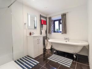 a white bathroom with a tub and a sink at Dovetail Cottage in Llangollen +17 photos