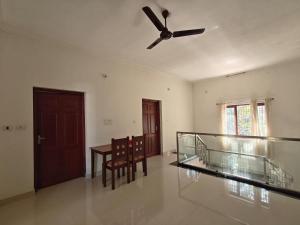 a living room with a ceiling fan and a table at Pratheeksha Homestay in Kannur