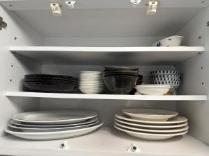 a white cabinet with plates and bowls on shelves at House KIMIJIMA in Yachimata +22 photos