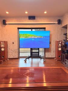 a large flat screen tv in a room with speakers at House KIMIJIMA in Yachimata