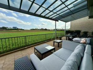 a couch on a patio with a view of a baseball field at House KIMIJIMA in Yachimata