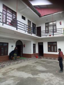 two men are working on the inside of a building at Bhaderwah Valley Resort in Bhadarwāh