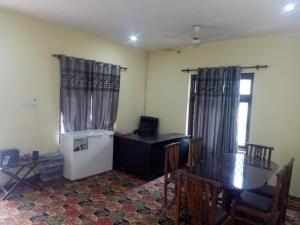 a kitchen with a desk and a refrigerator and a table at Bhaderwah Valley Resort in Bhadarwāh